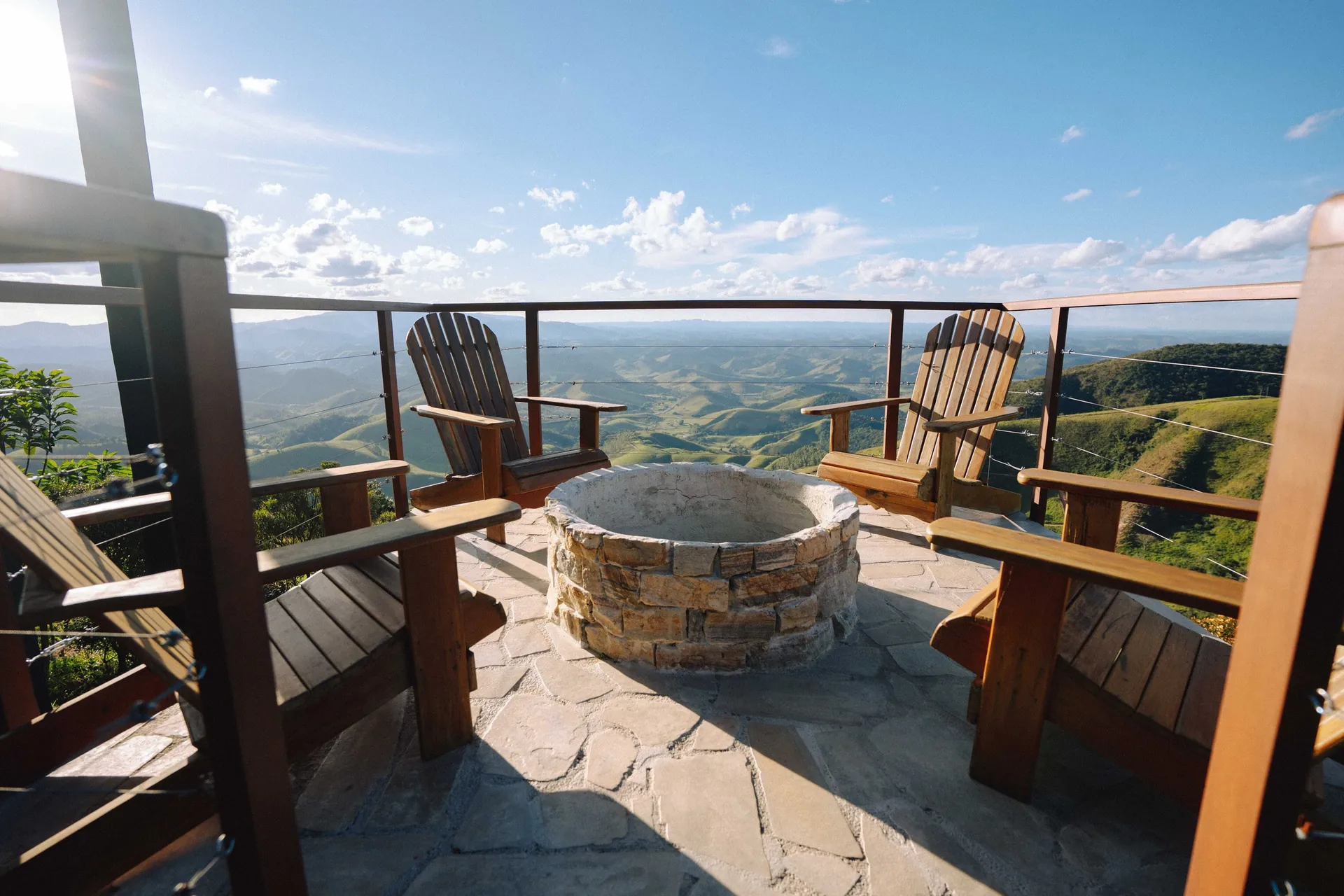 Firepit de pedra com poltronas de madeira no deck