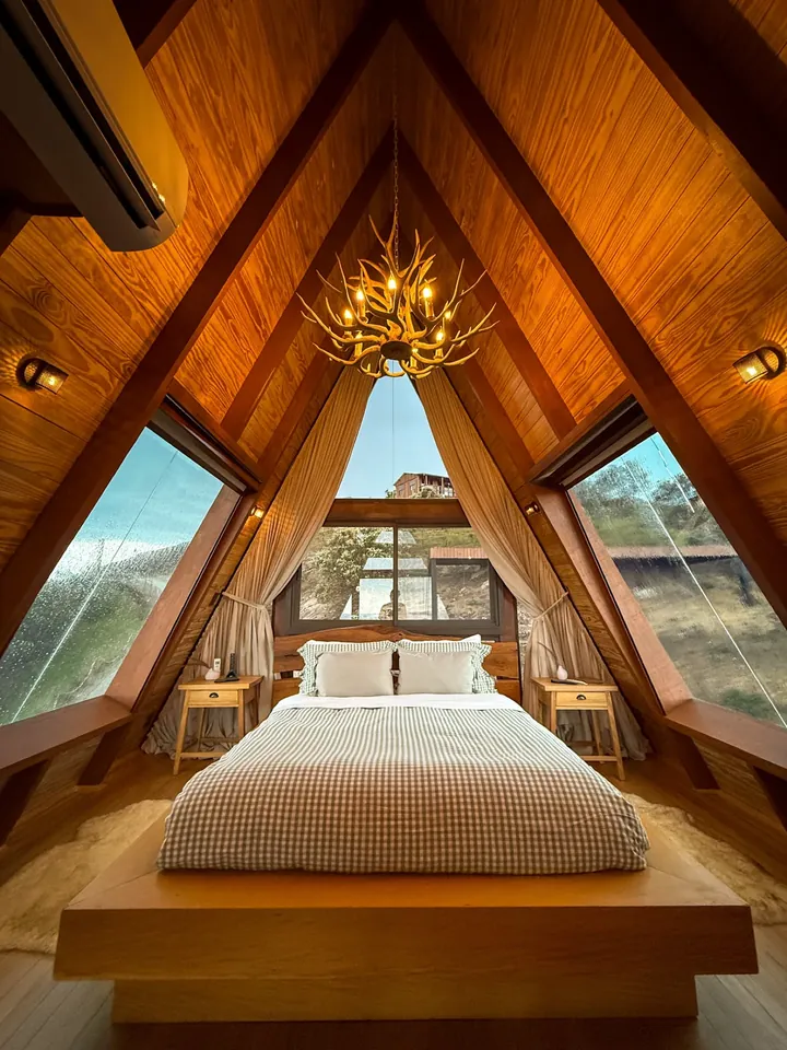 Cama queen no mezanino, sob as claraboias do telhado A-frame