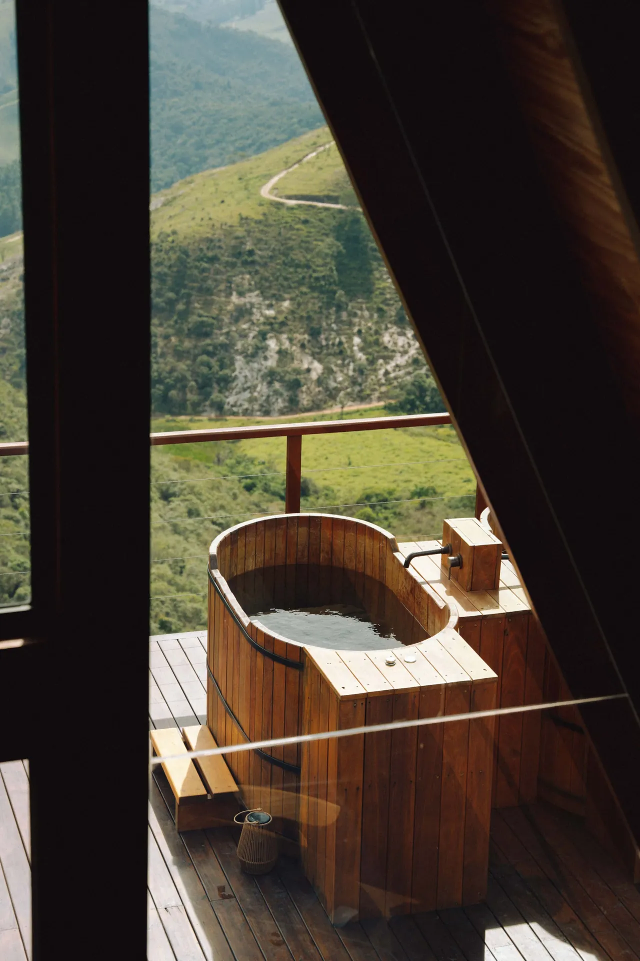 Ofurô de cedro com toalhas dobradas e a serra ao fundo